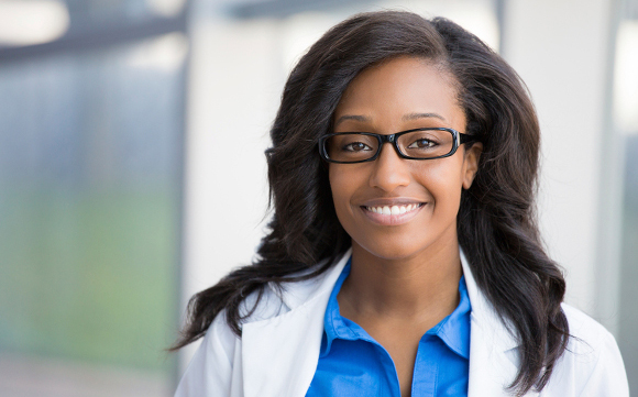 Dentist in coat and glasses in office setting