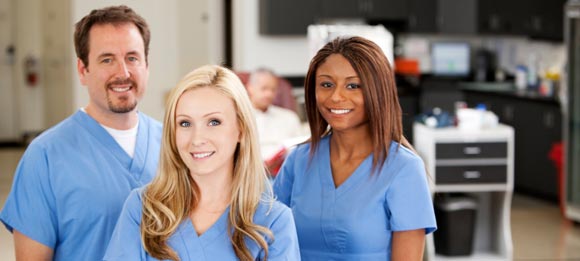 Smiling dental technicians in dentist office